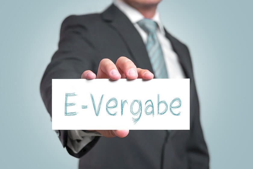 Man hält Schild mit e-Vergabe