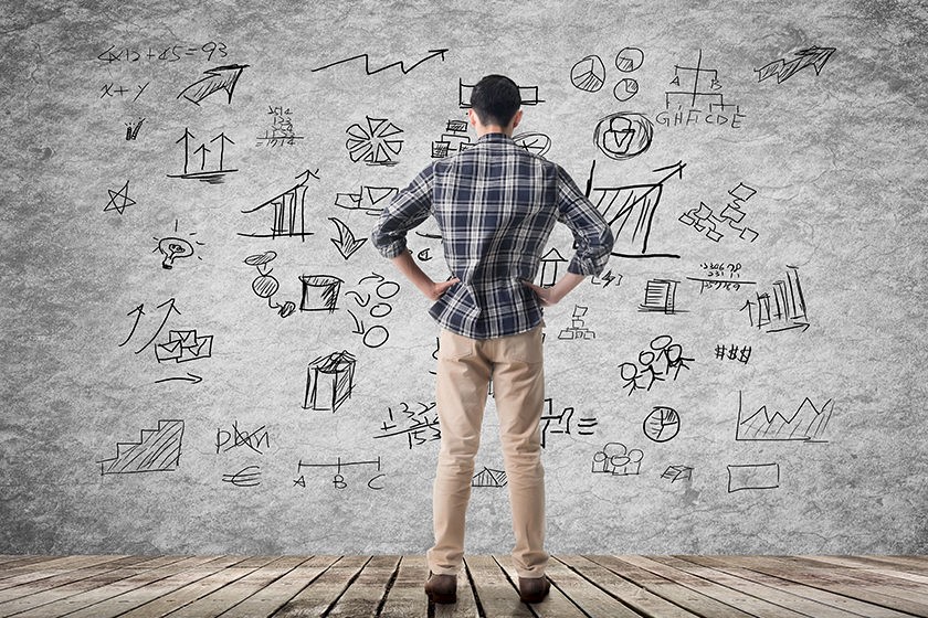 Mann steht vor einer Wand mit zahlreichen Informationen zur Wettbewwerbsanalyse