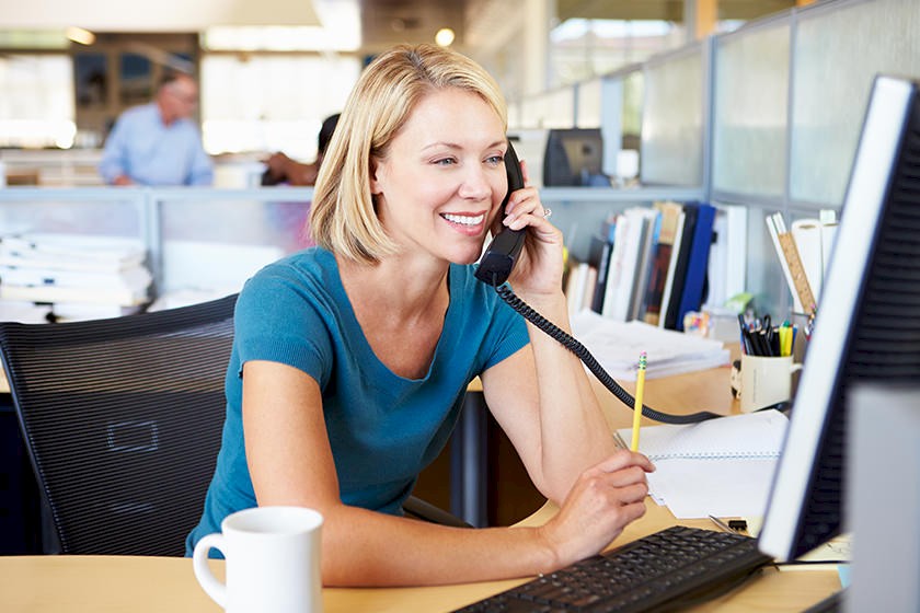 Mitarbeiterin telefoniert, um den passenden Ansprechpartner für die Kaltakquise zu finden