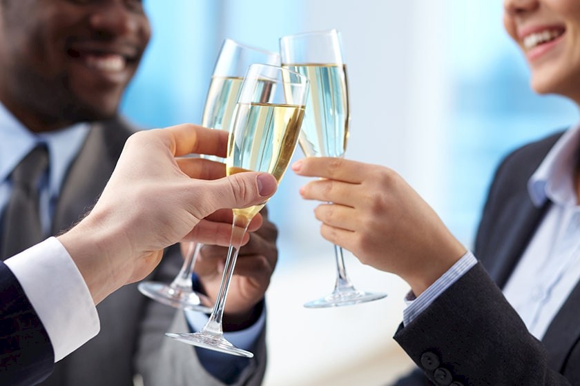 Drei Personen stoßen mit Sekt - können Sie für diese Freizeitgestaltung gekündigt werden?