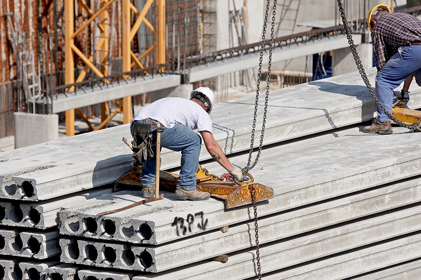 Rückenschmerzen am Bau: Handwerker hebt eine schwere Last