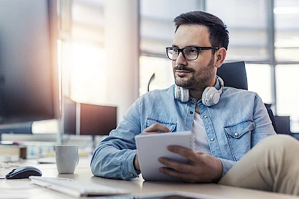 Mitarbeiter verschafft sich am PC einen Überblick über Verhandlungsstrategien