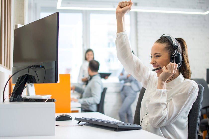 Mitarbeiterin freut sich über Verkauf dank optimaler B2B-Vertriebsstrategie