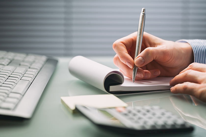 Person am Schreibtisch bei der Preiskalkulation