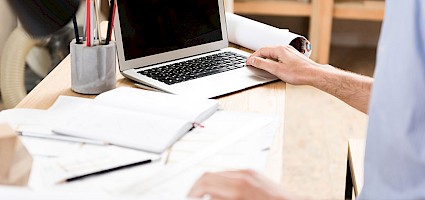 Person am PC betreibt B2B-Vertrieb aus dem Homeoffice