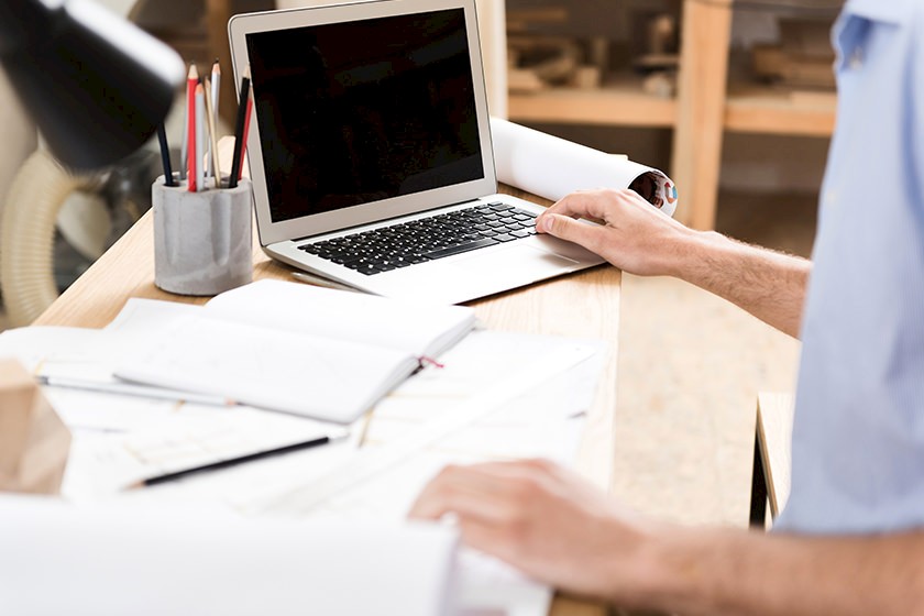 Person am PC betreibt B2B-Vertrieb aus dem Homeoffice