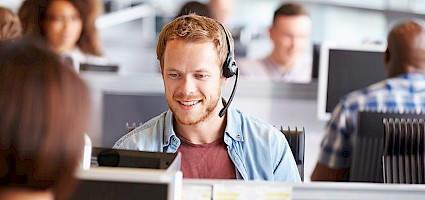 Vertriebsteam aufbauen: Sales Mitarbeiter mit Headset telefoniert
