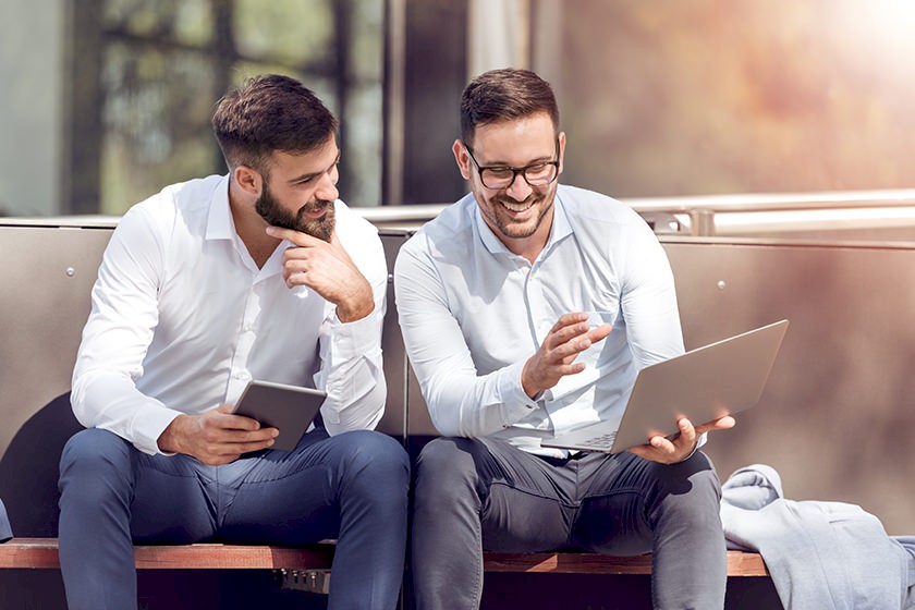 Newcomer im Vergabeverfahren: Zwei Männer sitzen lächelnd nebeneinander.