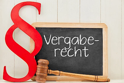 Schild mit Aufschrift "Vergaberecht" und Paragraf-Zeichen