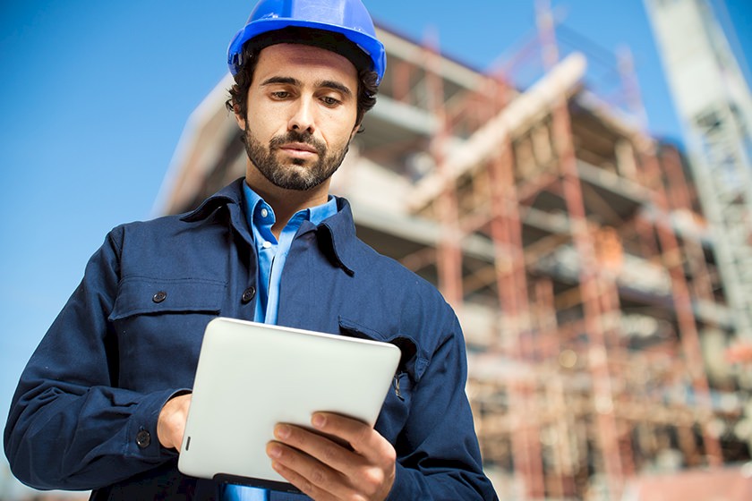 Bautrends: Mann auf Baustelle arbeitet mit Tablet