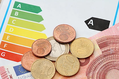 Eigenheimförderung: Geldschein und Münzen auf Energieeffizienz-Sticker