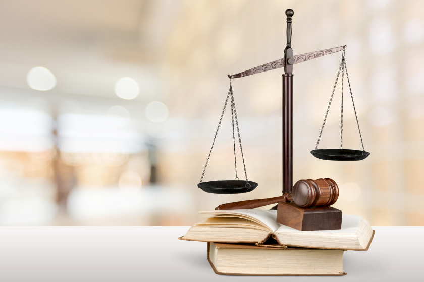 Waage, Richterhammer und Bücher als Rechtssymbole