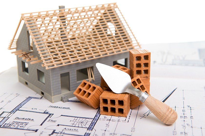 Ein Modell eines Hauses mit darunterliegenden Plänen