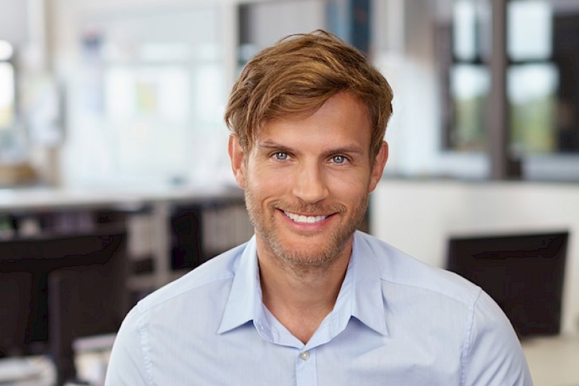 Ein Data Officer / Analyst lächelt in die Kamera