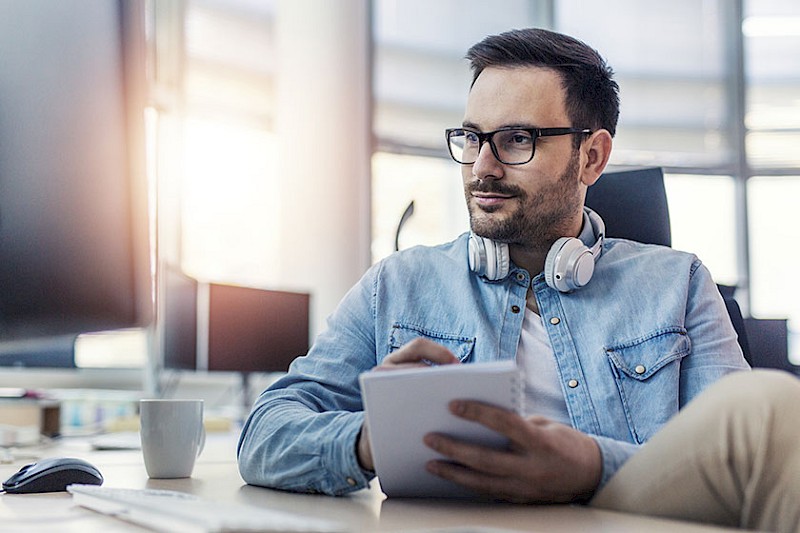 Mann liest ibau Tipps & Tricks am PC